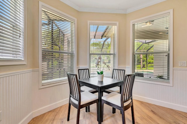 6364 Golden Eye Gln, Lakewood Ranch, FL 34202 - dining space with wainscoting, light wood finished floors, and ornamental molding