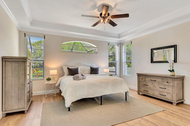 6364 Golden Eye Gln, Lakewood Ranch, FL 34202 - bedroom featuring crown molding, light wood-style floors, a tray ceiling, and ceiling fan