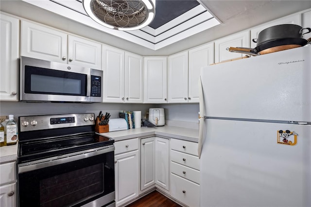 1452 SW 25th Pl Unit D4, Gainesville, FL 32608 - kitchen with stainless steel appliances, light countertops, white cabinetry, and dark wood-style floors