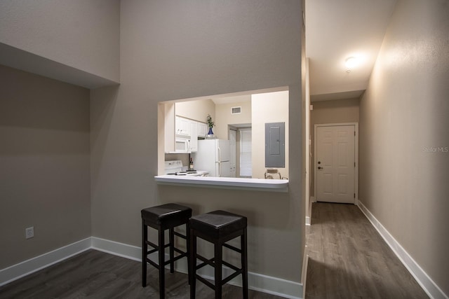 9177 SW 52nd Rd Unit E302, Gainesville, FL 32608 - kitchen with white appliances, electric panel, dark wood-style floors, white cabinets, and a towering ceiling