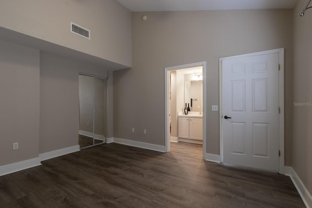9177 SW 52nd Rd Unit E302, Gainesville, FL 32608 - unfurnished bedroom featuring a high ceiling, dark wood-style floors, a closet, and ensuite bath