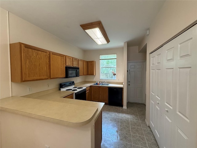 3901 SW 20th Ave Unit 611, Gainesville, FL 32607 - kitchen featuring black appliances, brown cabinetry, light countertops, and a peninsula