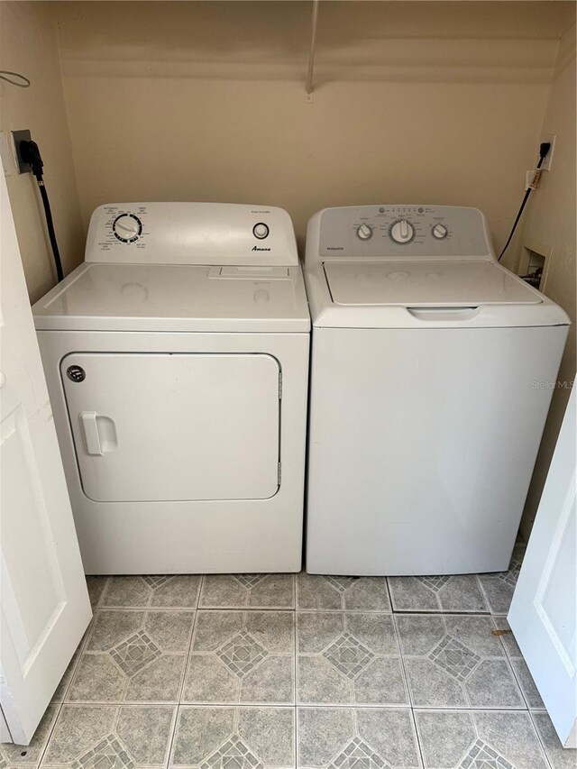 3901 SW 20th Ave Unit 611, Gainesville, FL 32607 - laundry room with washing machine and clothes dryer and light tile patterned flooring