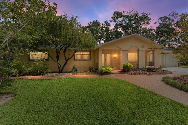 4700 NW 19th Pl, Gainesville, FL 32605 - view of front of house with stucco siding, a lawn, and decorative driveway