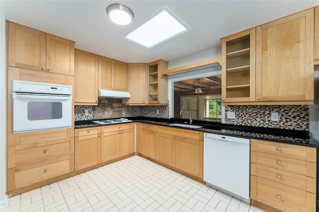 4700 NW 19th Pl, Gainesville, FL 32605 - kitchen with white appliances, light brown cabinetry, under cabinet range hood, dark countertops, and glass insert cabinets