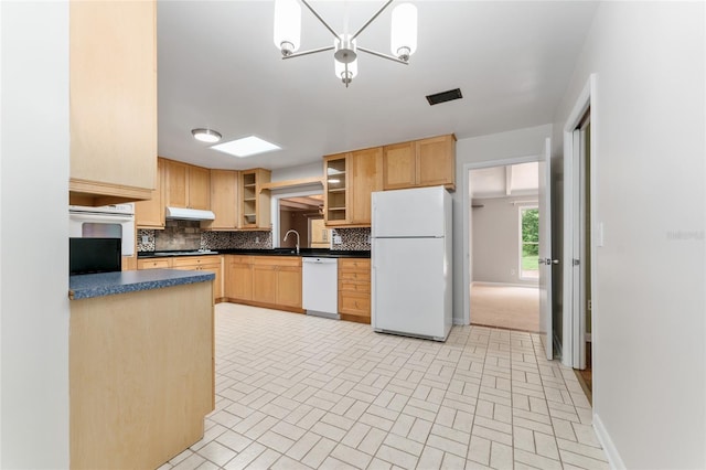 4700 NW 19th Pl, Gainesville, FL 32605 - kitchen with white appliances, dark countertops, under cabinet range hood, backsplash, and light brown cabinetry
