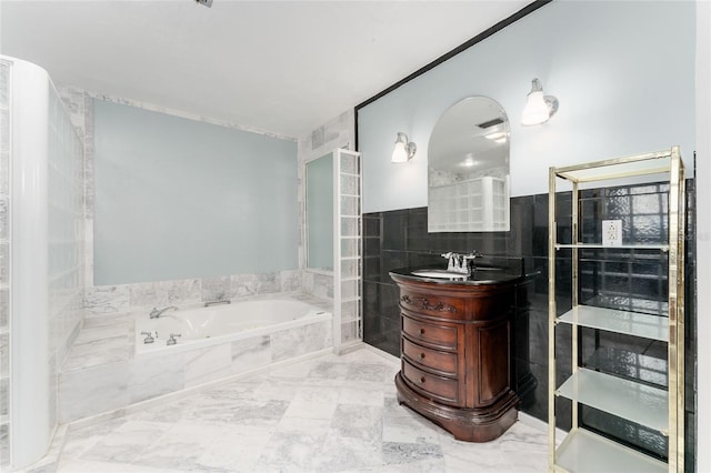 4700 NW 19th Pl, Gainesville, FL 32605 - bathroom with tile walls, a garden tub, vanity, and marble finish flooring