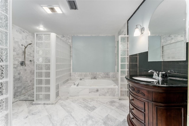 4700 NW 19th Pl, Gainesville, FL 32605 - bathroom featuring a garden tub, a walk in shower, vanity, tile walls, and marble look tile flooring