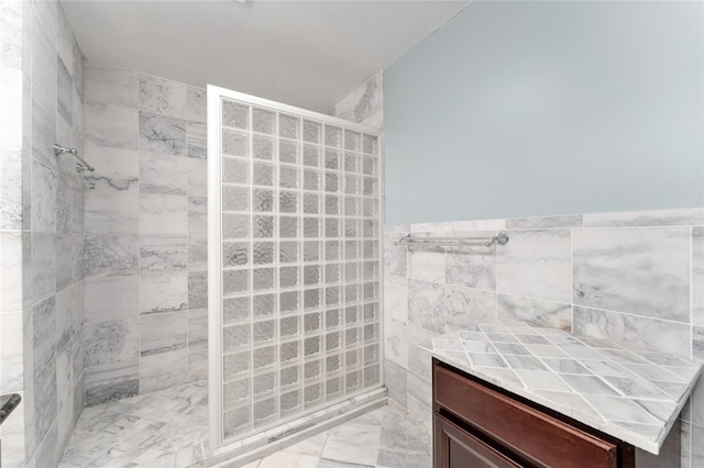 4700 NW 19th Pl, Gainesville, FL 32605 - bathroom featuring a walk in shower, tile walls, marble finish floors, and a wainscoted wall