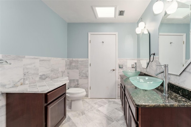 4700 NW 19th Pl, Gainesville, FL 32605 - bathroom with tile walls, double vanity, and wainscoting