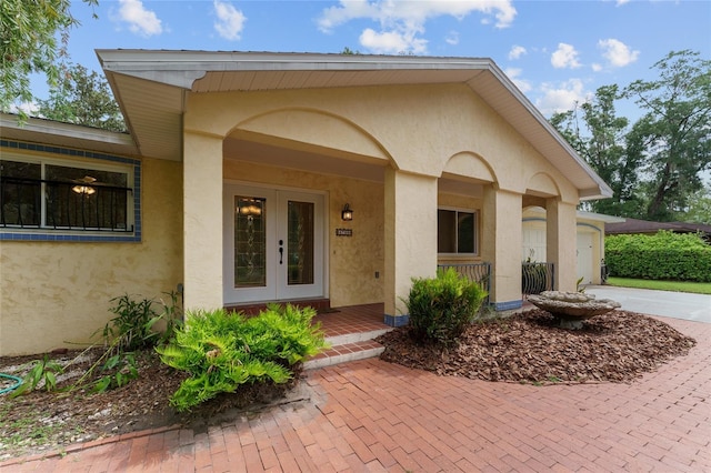 4700 NW 19th Pl, Gainesville, FL 32605 - view of exterior entry featuring french doors, stucco siding, and driveway