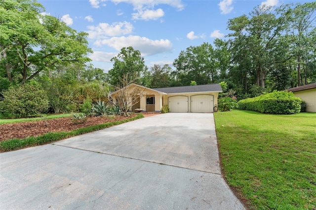 4700 NW 19th Pl, Gainesville, FL 32605 - view of front of property with a garage, concrete driveway, a front yard, stucco siding, and view of wooded area