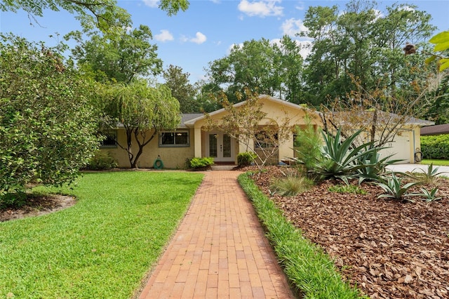 4700 NW 19th Pl, Gainesville, FL 32605 - single story home featuring french doors, a front yard, stucco siding, and an attached garage