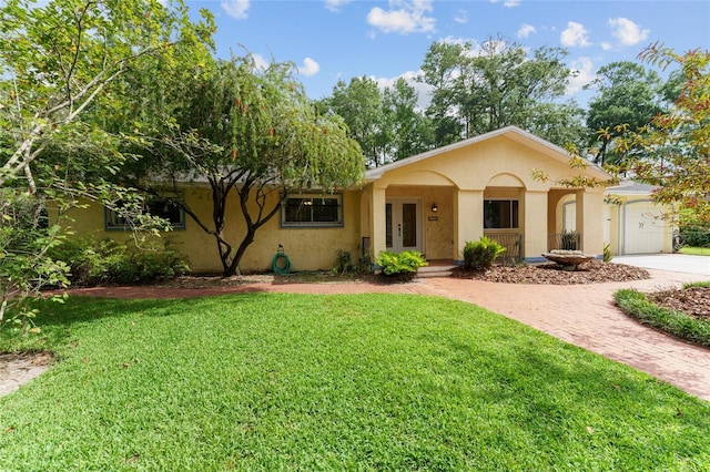 4700 NW 19th Pl, Gainesville, FL 32605 - single story home with stucco siding, french doors, a front lawn, and decorative driveway