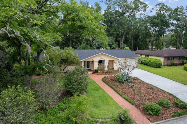 4700 NW 19th Pl, Gainesville, FL 32605 - single story home with concrete driveway, a front lawn, an attached garage, and a shingled roof