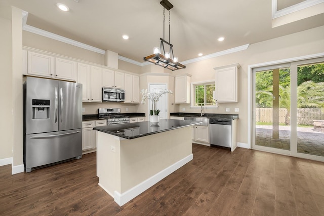 6316 SW 50th St, Gainesville, FL 32608 - kitchen with appliances with stainless steel finishes, crown molding, white cabinets, a center island, and dark countertops