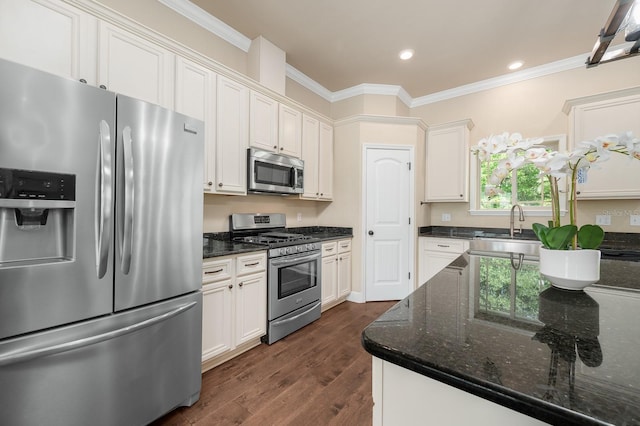 6316 SW 50th St, Gainesville, FL 32608 - kitchen with appliances with stainless steel finishes, ornamental molding, dark wood-type flooring, dark stone countertops, and white cabinetry