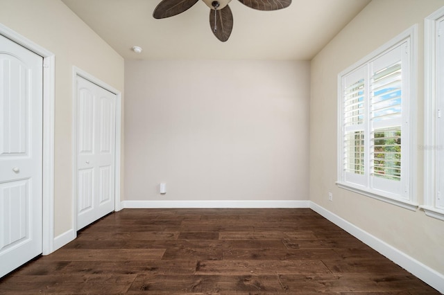 6316 SW 50th St, Gainesville, FL 32608 - unfurnished bedroom featuring multiple windows, dark wood-style flooring, and a ceiling fan