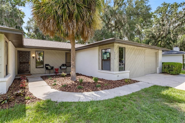 2330 NW 54th Ter, Gainesville, FL 32606 - view of side of property with driveway, a lawn, and a garage