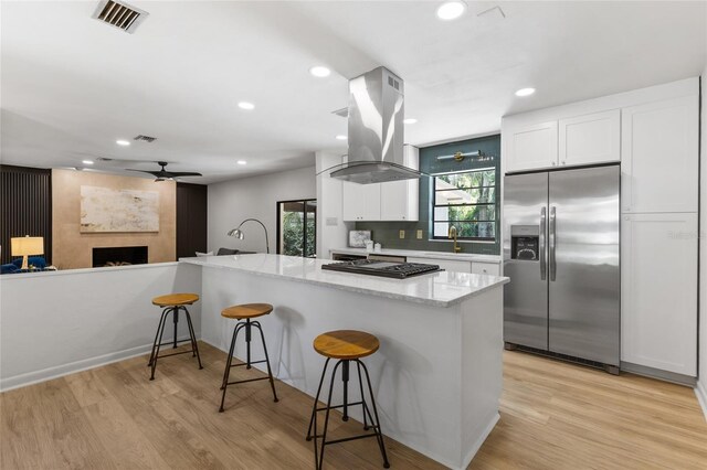 2330 NW 54th Ter, Gainesville, FL 32606 - kitchen featuring appliances with stainless steel finishes, a ceiling fan, island exhaust hood, white cabinets, and recessed lighting