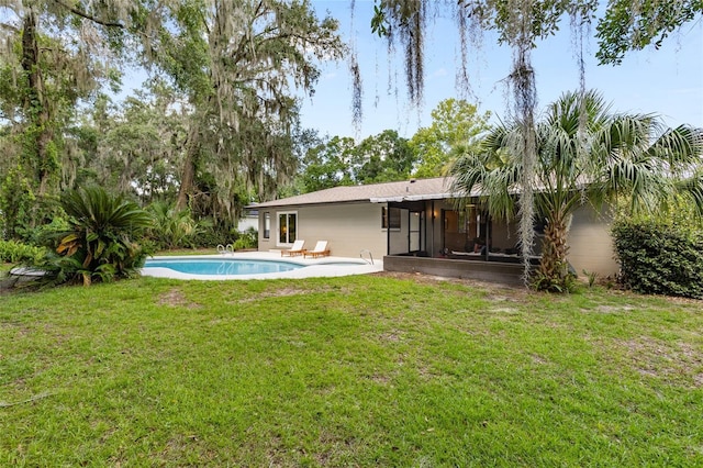 2330 NW 54th Ter, Gainesville, FL 32606 - back of property featuring a sunroom, an outdoor pool, and a lawn