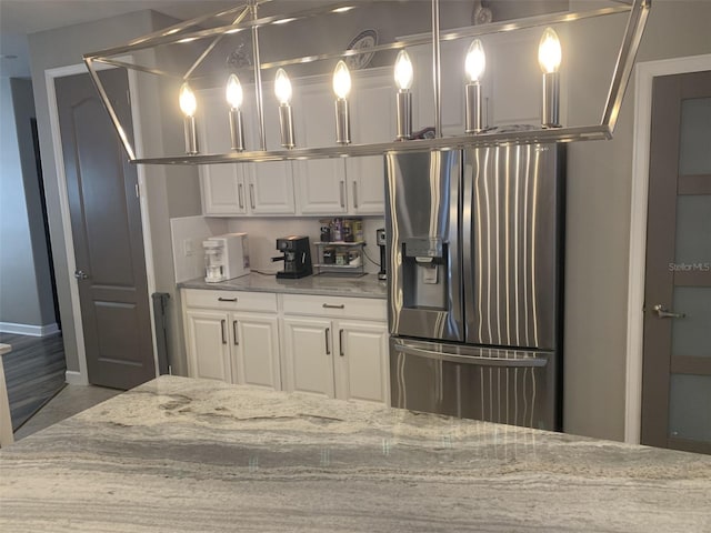2048 Bristol Grande Way, Orlando, FL 32820 - kitchen with stainless steel fridge with ice dispenser, white cabinetry, and light stone countertops