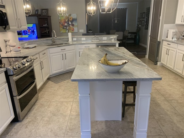 2048 Bristol Grande Way, Orlando, FL 32820 - kitchen featuring stainless steel appliances, a chandelier, a peninsula, a kitchen breakfast bar, and white cabinetry