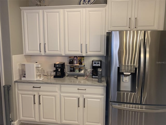 2048 Bristol Grande Way, Orlando, FL 32820 - kitchen featuring stainless steel fridge, white cabinets, and light stone counters