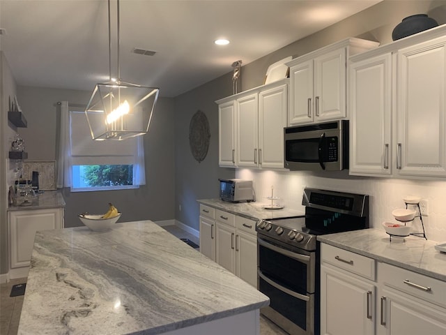 2048 Bristol Grande Way, Orlando, FL 32820 - kitchen featuring stainless steel appliances, white cabinets, light stone countertops, hanging light fixtures, and a kitchen island