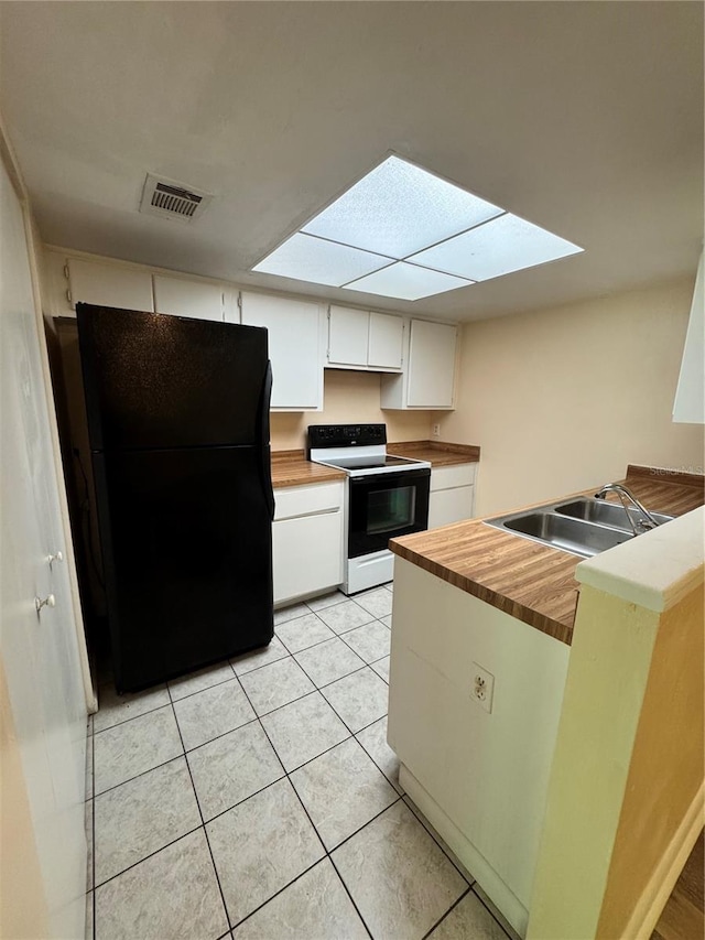 4224 SW 70th Ter Unit A, Gainesville, FL 32608 - kitchen with electric range, freestanding refrigerator, white cabinetry, a peninsula, and butcher block countertops
