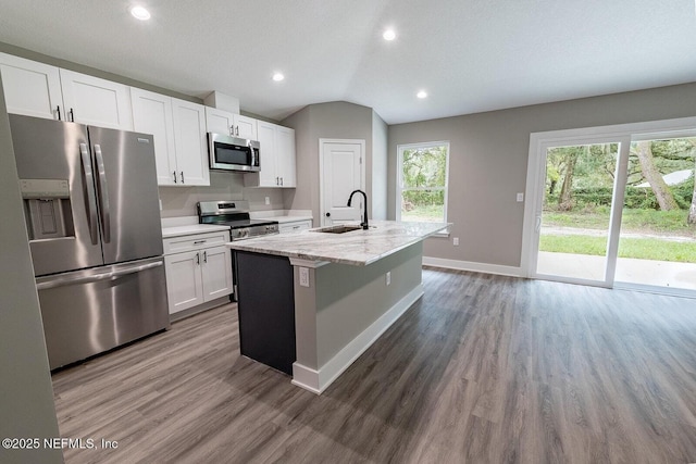 1262 Coral Farms Rd, Florahome, FL 32140 - kitchen with appliances with stainless steel finishes, wood finished floors, white cabinetry, a center island with sink, and recessed lighting