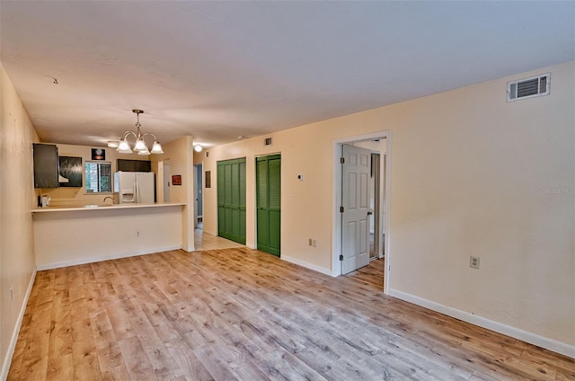 89 SE 16th Ave Unit P102, Gainesville, FL 32601 - unfurnished living room with a chandelier and light wood-type flooring