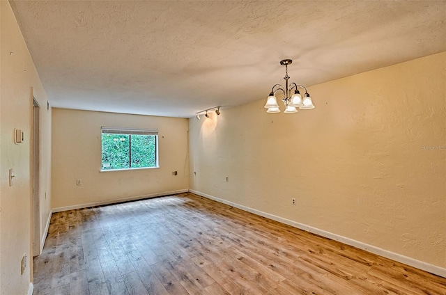 89 SE 16th Ave Unit P102, Gainesville, FL 32601 - spare room with wood finished floors, a chandelier, and a textured ceiling