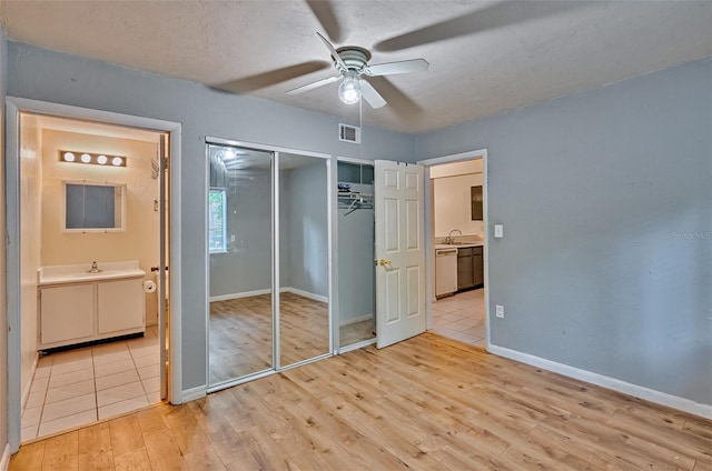 89 SE 16th Ave Unit P102, Gainesville, FL 32601 - unfurnished bedroom with light wood-style flooring, ensuite bath, a closet, and ceiling fan