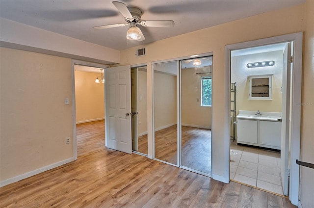 89 SE 16th Ave Unit P102, Gainesville, FL 32601 - unfurnished bedroom featuring light wood finished floors, two closets, ceiling fan, and ensuite bathroom