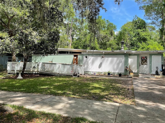 2603 NE 12th St, Gainesville, FL 32609 - mid-century home featuring a front lawn and view of scattered trees