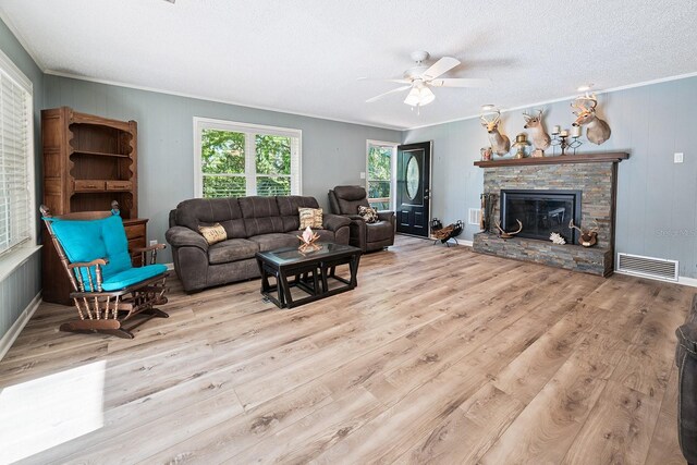 145 SE 904th Ave, Suwannee, FL 32692 - living area featuring ceiling fan, wood finished floors, ornamental molding, a fireplace, and a textured ceiling