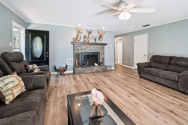 145 SE 904th Ave, Suwannee, FL 32692 - living area with crown molding, wood finished floors, a textured ceiling, a ceiling fan, and a fireplace