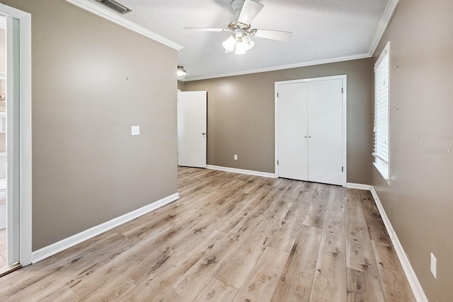 145 SE 904th Ave, Suwannee, FL 32692 - unfurnished bedroom with ornamental molding, light wood-type flooring, a closet, a ceiling fan, and a textured ceiling