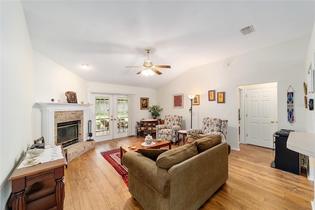 1602 NW 117th Ter, Gainesville, FL 32606 - living room with vaulted ceiling, a ceiling fan, light wood-type flooring, french doors, and a brick fireplace