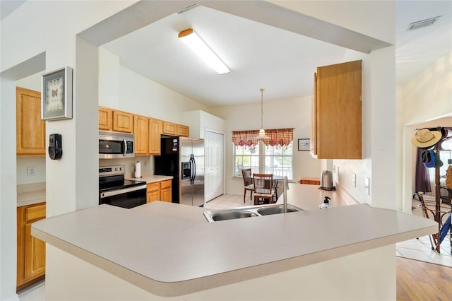 1602 NW 117th Ter, Gainesville, FL 32606 - kitchen with stainless steel appliances, hanging light fixtures, light countertops, a peninsula, and light wood-type flooring