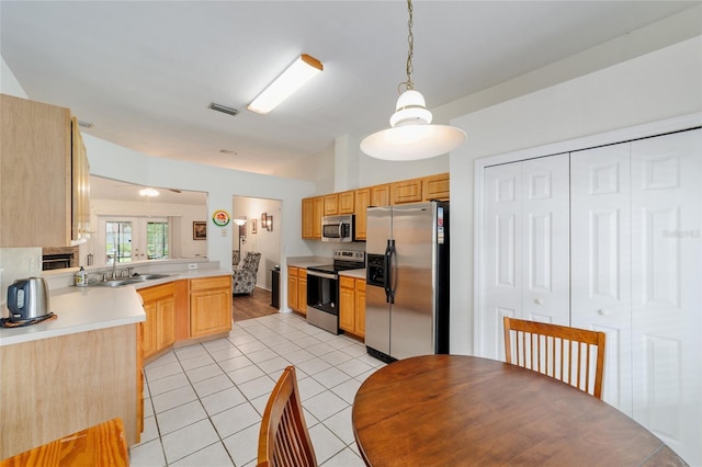 1602 NW 117th Ter, Gainesville, FL 32606 - kitchen featuring stainless steel appliances, light tile patterned floors, light countertops, pendant lighting, and a peninsula