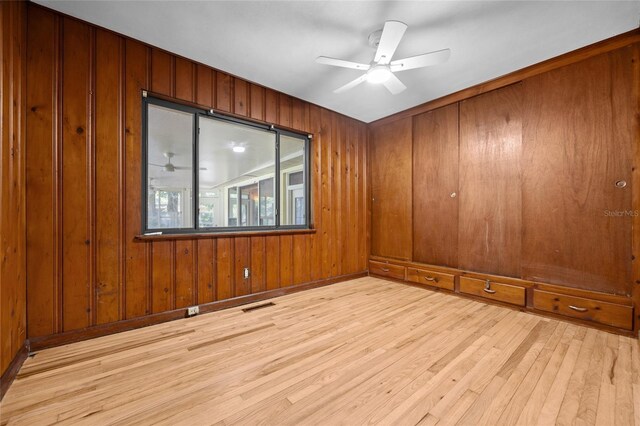 2225 NE 6th Ter, Gainesville, FL 32609 - spare room featuring wood finished floors, a ceiling fan, and wooden walls