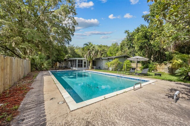 2225 NE 6th Ter, Gainesville, FL 32609 - view of swimming pool with a fenced backyard, a patio, and a sunroom