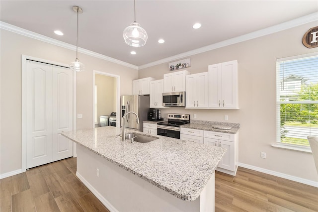 2782 SW 120th Dr, Gainesville, FL 32608 - kitchen with appliances with stainless steel finishes, white cabinetry, light wood-style floors, an island with sink, and ornamental molding