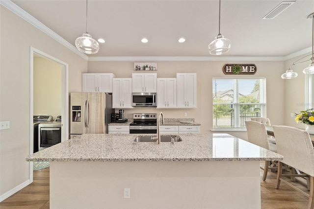 2782 SW 120th Dr, Gainesville, FL 32608 - kitchen featuring stainless steel appliances, separate washer and dryer, crown molding, white cabinets, and light wood-type flooring