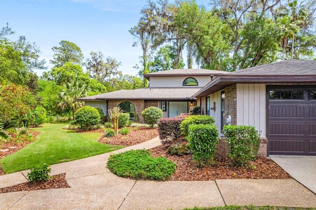 8321 SW 23rd Pl, Gainesville, FL 32607 - view of front of property featuring a front lawn, a shingled roof, a garage, and stone siding