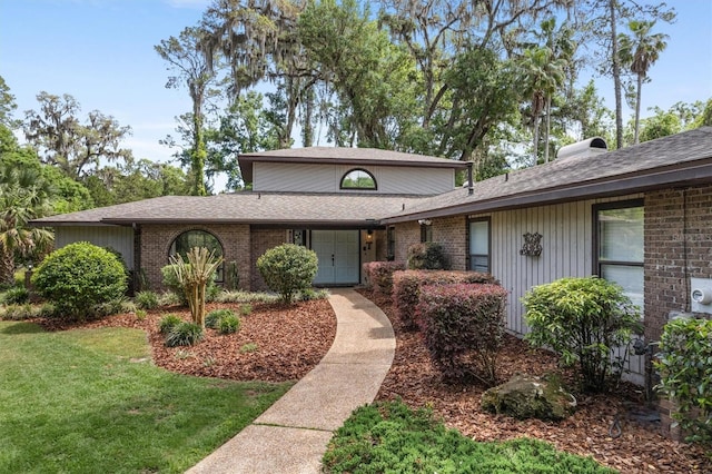 8321 SW 23rd Pl, Gainesville, FL 32607 - view of front of house with roof with shingles, brick siding, and a front lawn