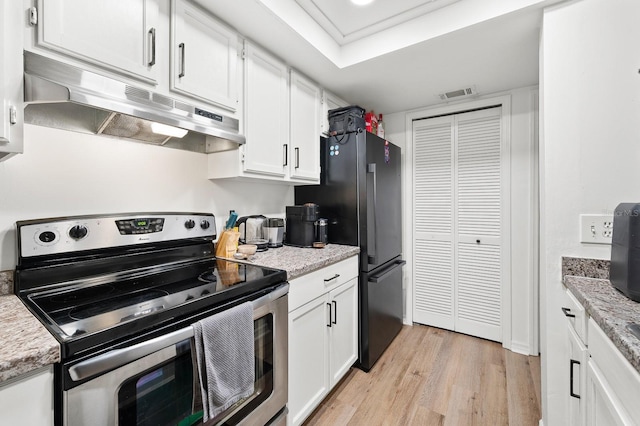 900 SW 62nd Blvd Unit I56, Gainesville, FL 32607 - kitchen with stainless steel range with electric stovetop, under cabinet range hood, light wood-style floors, white cabinets, and freestanding refrigerator
