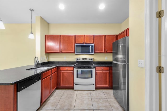 2960 SW 35th Pl Unit 66, Gainesville, FL 32608 - kitchen featuring stainless steel appliances, a peninsula, reddish brown cabinets, and light tile patterned flooring
